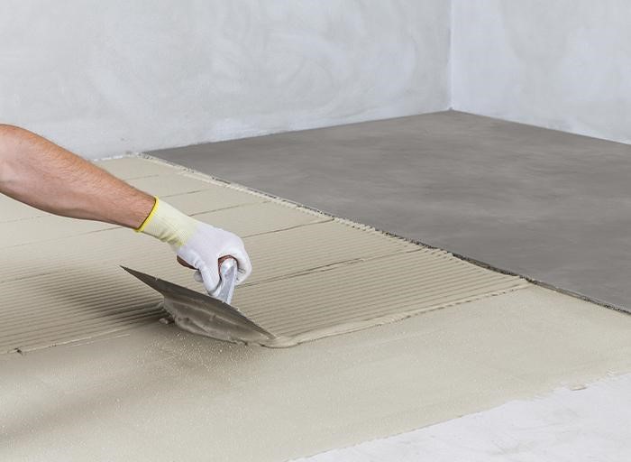 Rovnoměrné roztírání lepidla před pokládkou.